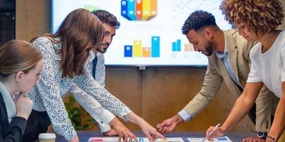 Workers discuss metrics in a conference room