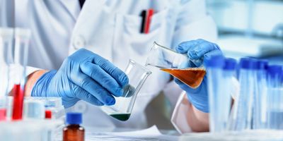 Lab tech mixing two liquids together