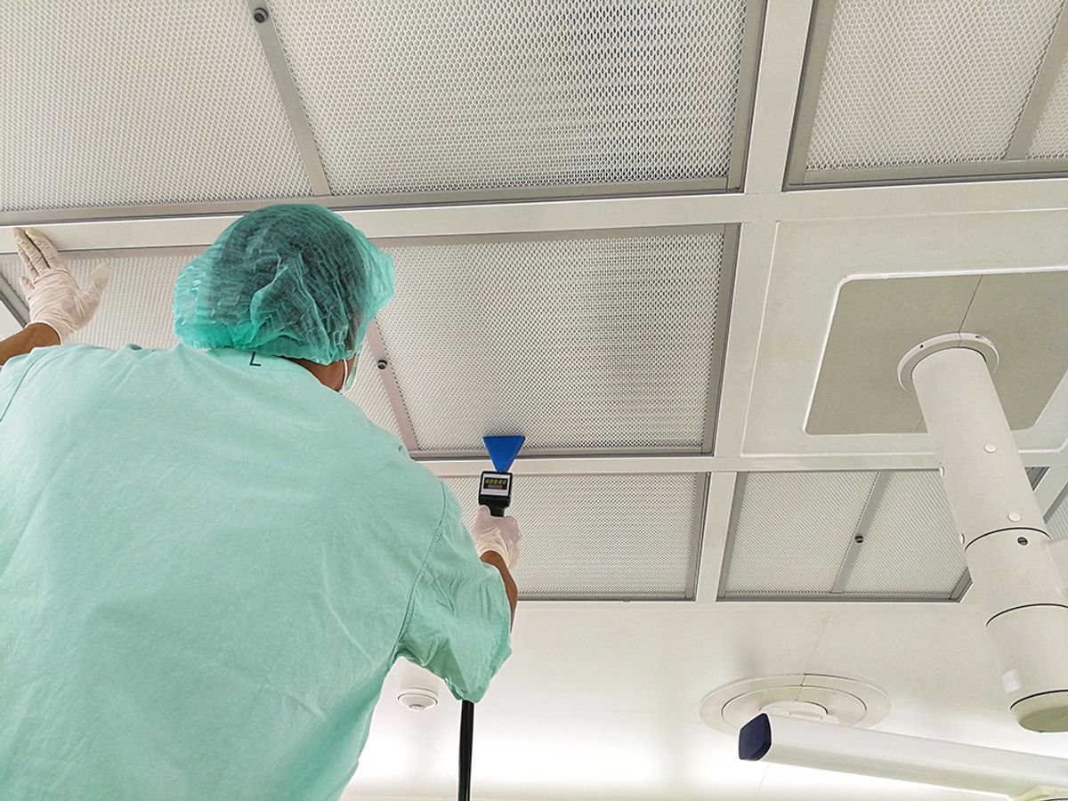 Worker in PPE tests HEPA filters in lab Worker in PPE tests HEPA filters in lab