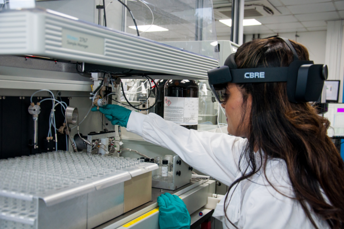 Lab technician services a liquid handler with a mixed reality headset Lab technician services a liquid handler with a mixed reality headset